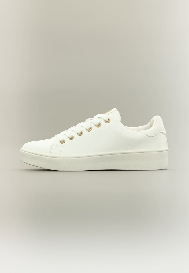 Λευκό αθλητικό παπούτσι από συνθετικό υλικό, με επίπεδη σόλα, στρογγυλεμένη μύτη, χρυσά κρικάκια και μινιμαλιστικό σχεδιασμό.