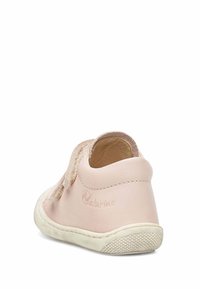 Pink leather shoe with a textured, beige fabric accent. Features a rounded shape and a white rubber sole with a grip pattern.