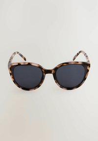 Lunettes de soleil œil de chat avec une monture en écaille de tortue, des verres noirs et des branches fines et définies avec un motif rayé.