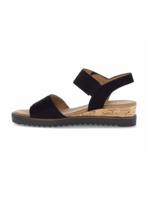 Schwarze offene Sandale mit breitem Knöchelriemen, Kork-Keilabsatz und schwarzer profillierter Sohle vor weißem Hintergrund.