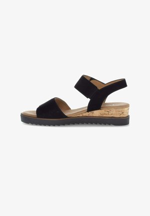 Schwarze offene Sandale mit breitem Knöchelriemen, Kork-Keilabsatz und schwarzer profillierter Sohle vor weißem Hintergrund.