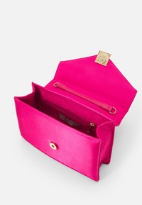 Fuchsia satijnen clutch met een gouden drukknoopsluiting, voorzien van een binnenvak met rits en een gladde textuur. Compact rechthoekig ontwerp.