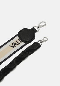 Melnas ādas siksna ar austo tekstūru, ar beigu un melnu svītru lente, kas satur "VALENTINO" logo un sudraba metāla sprādzes.