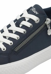 Sneaker blu navy con lacci bianchi, dotata di una zip laterale e suola bianca testurizzata. I materiali includono una tomaia sintetica e suola in gomma.