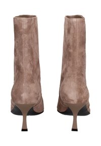 Een paar taupe suede laarzen tot de middenkuit met spitse stiletto-hakken, bekeken vanaf de achterkant op een witte achtergrond.