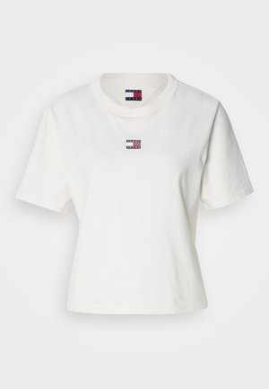 Bílý krátký rukáv tričko vyrobené z bavlny s kulatým výstřihem. Obsahuje malé vyšívané logo v červené, bílé a modré na hrudi.