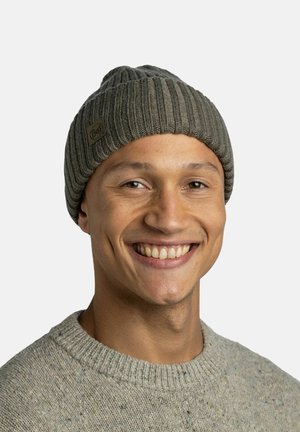 Knit beanie in gray with ribbed texture and turned-up brim; features a small brown label with "Buff" logo. Worn by a smiling individual.