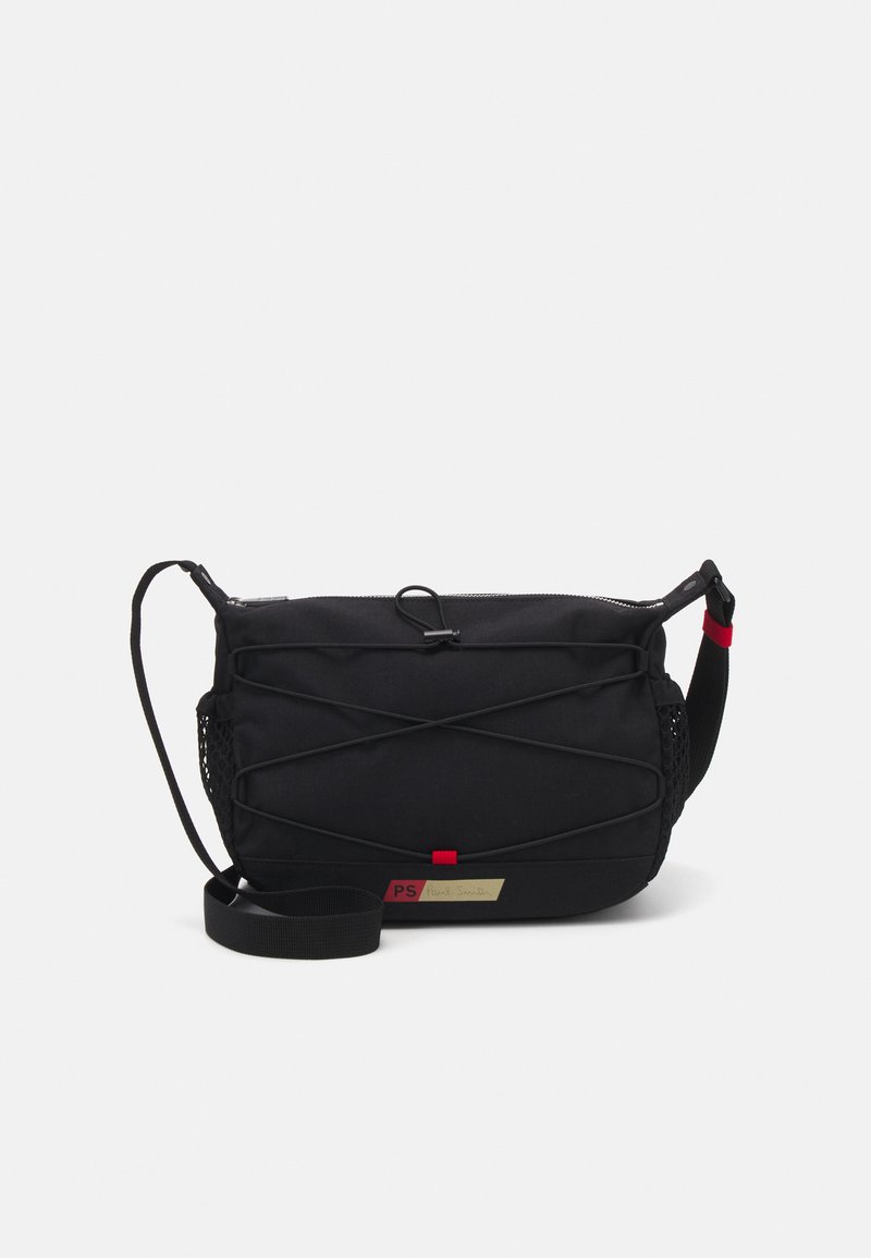 Borsa a tracolla nera realizzata in tessuto resistente, con chiusura a zip, tasca laterale in rete e dettagli in design elastico. Etichetta dorata con logo.
