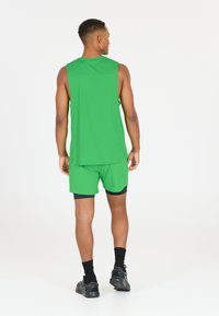 Grön sportig linne och shorts-set, med ett lätt tyg, ärmlös design och kontrasterande svart kant.
