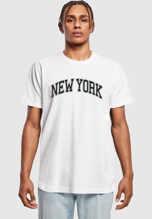 Bijela pamučna majica s natpisom "NEW YORK" u podebljanom crnom tekstu preko prsnog dijela. Kratki rukavi i klasični okrugli izrez.