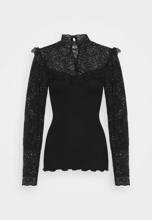 Haut noir moulant à manches longues avec col montant en dentelle, manches en dentelle, bordure à volants sur la poitrine et corps texturé uni.