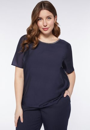 Blusa a maniche corte blu navy con una texture liscia e un collo rotondo decorato con una sottile rifinitura metallica. Adatta per un look casual.