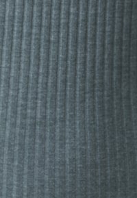 Tissu en maille côtelée de couleur bleu sarcelle doux, présentant des lignes verticales avec une texture douce et un éclat subtil.