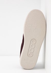 Fialová semišová bota s texturovanou bílou gumovou podrážkou, na které je vyražen název značky "ECCO" a velikost "37".