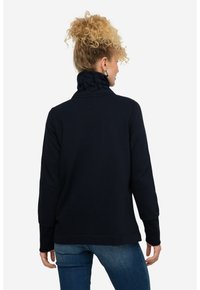 Sudadera de color azul marino con un cuello alto y puños acanalados, hecha de una tela suave, presenta un corte relajado y un dobladillo recto.