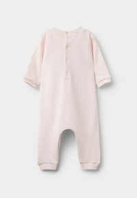 Różowy bawełniany kombinezon z długimi rękawami, okrągłym dekoltem i zapięciem na napy z tyłu. Żebrowane mankiety i luźne nogawki.