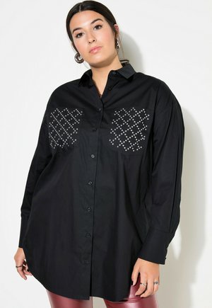 Camicia nera con bottoni e maniche lunghe, con dettagli in metallo argentato su due tasche frontali, realizzata in morbido cotone.