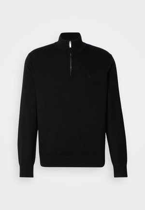 Schwarzer Reißverschluss-Pullover aus feinem Strickmaterial. Mit langen Ärmeln, einem hohen Kragen und einem kleinen Logo auf der Brust.