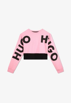 Lyserød cropped sweatshirt med store sorte "HUGO"-bogstaver på ærmerne og fronten, med en sort bundkant og en blød, glat tekstur.