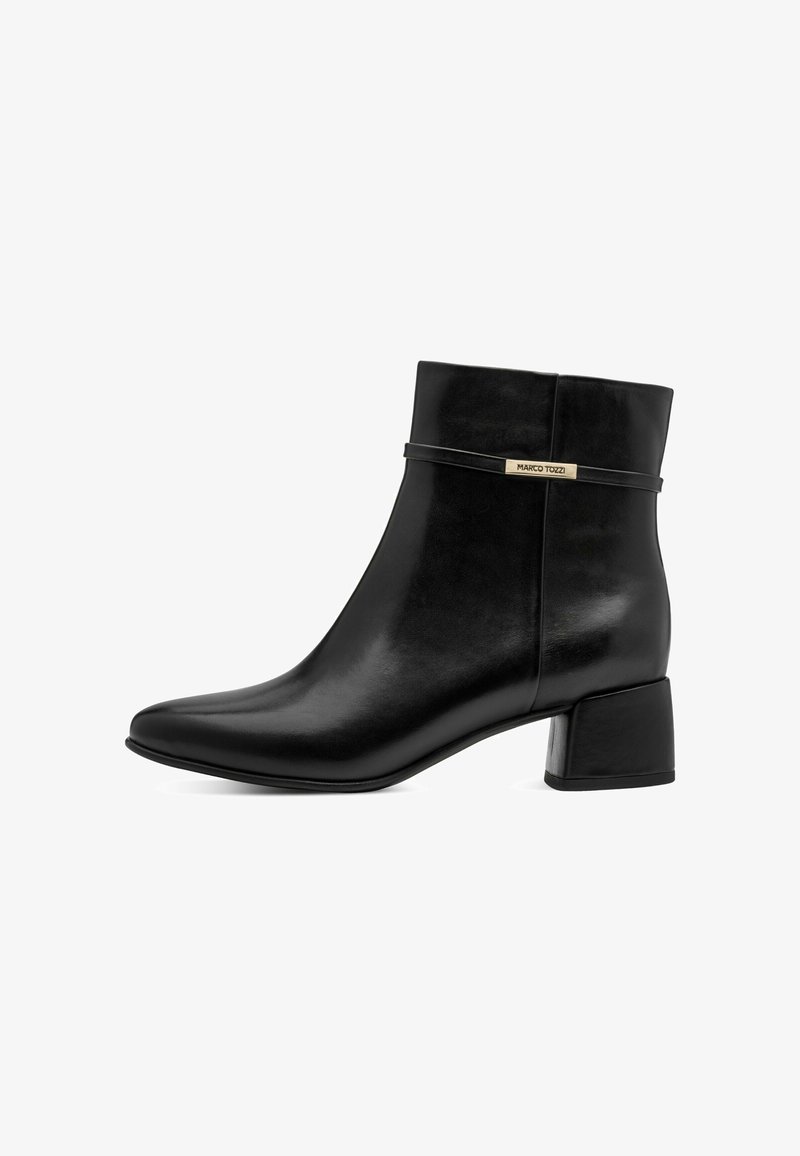 Bottine en cuir noir avec talon bloc, bout pointu et bride décorative portant une petite étiquette métallique "Marco Tozzi".