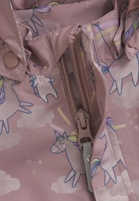 Ljust rosa jacka med mönster av enhörningar, moln och stjärnor. Inkluderar en beige dragkedja med YKK-dragögla och tryckknappar. Mjuk textur.