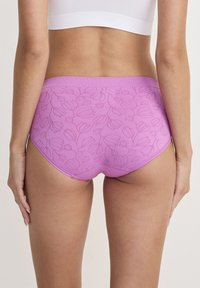 Roze ondergoed voor vrouwen met een bloemenpatroon en een hoog gesneden ontwerp. De stof is glad en heeft subtiele, reliëf bloemmotieven.