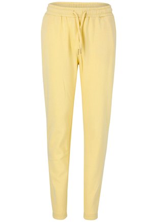 Gula sweatpants med dragsko i midjan, avsmalnande ben och mjuk tygtextur. Inga synliga mönster eller detajer i metall.