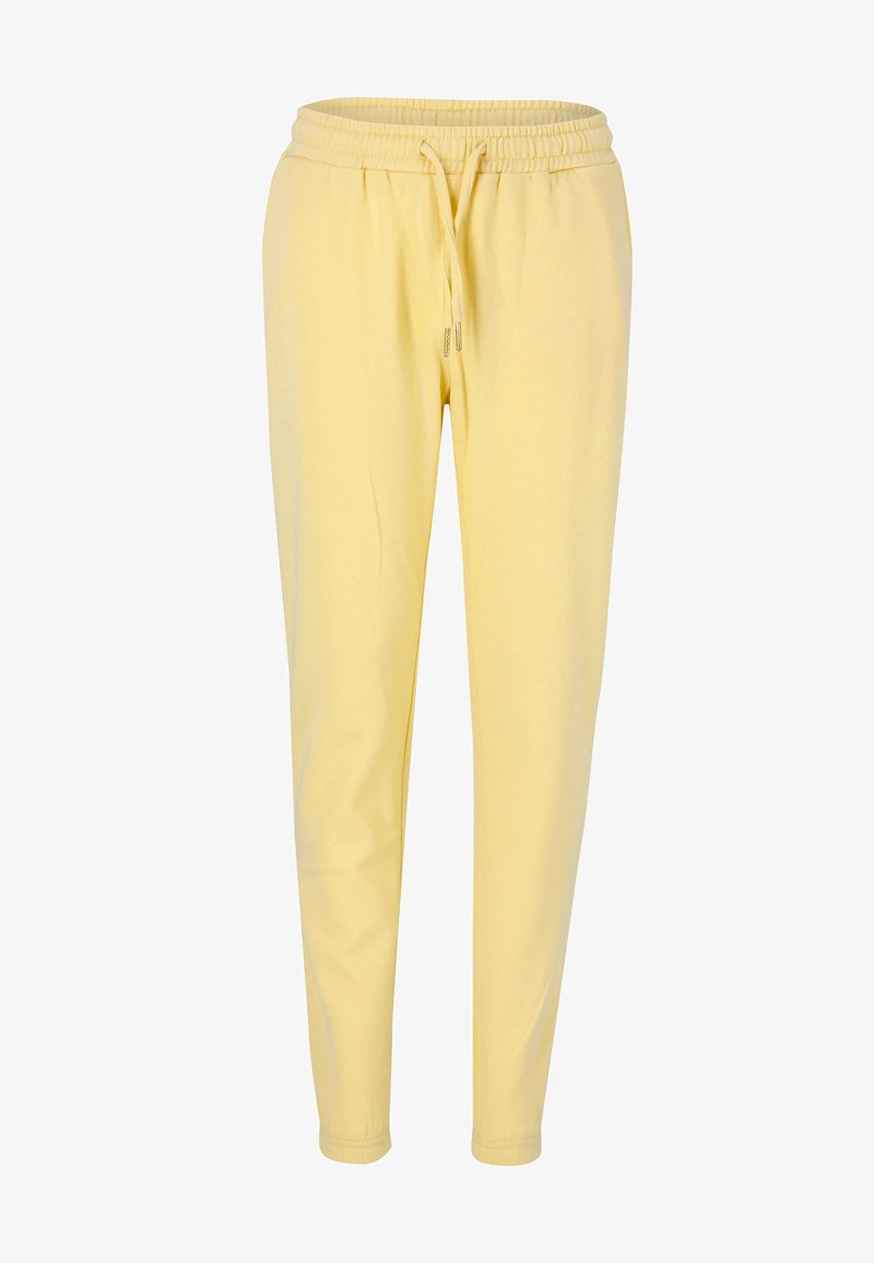 Gula sweatpants med dragsko i midjan, avsmalnande ben och mjuk tygtextur. Inga synliga mönster eller detajer i metall.