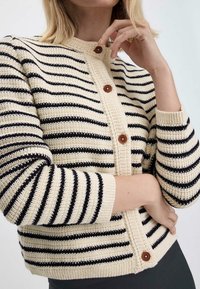 Gebreide cardigan met crèmekleurige en zwarte strepen, ronde hals, knoopsluiting aan de voorkant met bruine knopen, en geribde manchetten en zoom.