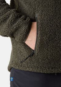 Giacca di pile verde oliva con superficie texturizzata. Presenta tasche a zip per le mani e cordini elasticizzati per le regolazioni.