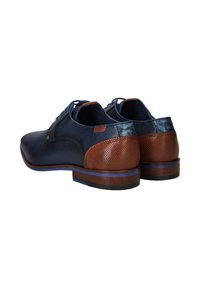 Marineblauwe schoenen van gestructureerd leer, met bruine geperforeerde accenten en massieve hakken. Bevat blauwe stiksels en contrasterende details aan de achterkant.