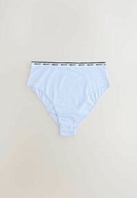 Culottes taille haute bleu clair avec ceinture élastique noire et blanche portant le texte répété « NEXT », posées à plat sur un fond uni.