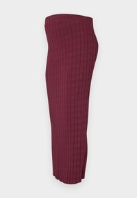 Burgundské žebrované pletené kalhoty úzkého střihu, s postranními rozparky na lemu pro větší pohyb a texturovaným povrchem látky.