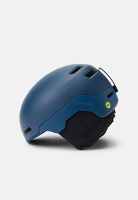 Blauer Helm mit einer glatten, matten Oberfläche. Verfügt über Lüftungsschlitze, einen verstellbaren Kinnriemen und ein gelbes MIPS-Logo an der Seite.