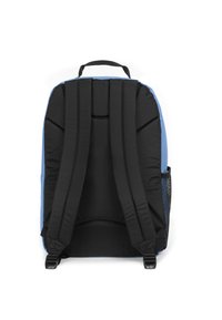 Mochila azul y negra con correas y respaldo acolchados, que cuenta con un bolsillo lateral de malla y costuras robustas. Material textil suave.