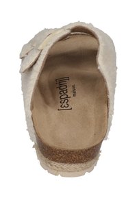 White fluffy slip-on sandal with a cork sole, featuring a textured interior and a logo on the insole. One strap adorned with a bow detail.