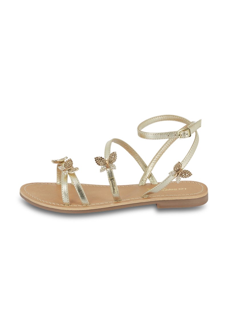 Sandali metallici dorati con tre sottili cinturini caratterizzati da dettagli a forma di farfalla e una suola piatta. Il cinturino alla caviglia include una fibbia regolabile.