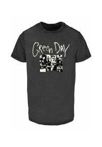 Sort bomulds t-shirt med korte ærmer. På forsiden står "Green Day" i hvid tekst over et gitter af sort-hvide billeder. Rund halsudskæring.