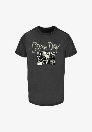 Fekete pamut póló rövid ujjakkal. Elöl a "Green Day" fehér betűkkel szerepel egy fekete-fehér képekből álló rács felett. Kerek nyakú.