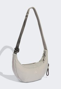 Ljusgrå axelväska med ett mjukt, vadderat ytterlager, justerbar rem och dragkedjeficka, med en diskret logodetalj.