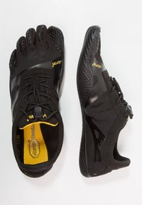 Schwarze Zehenschuhe mit fünf Zehen, einer strukturierten Oberseite und einer Gummisohle. Verfügt über ein sicheres Schnürdesign und ein Vibram-Logo an der Seite und auf der Innensohle.