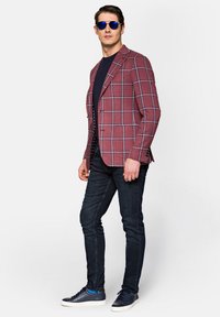 Czerwono-granatowa marynarka w kratę, zestawiona z granatowym T-shirtem, ciemnymi dżinsami i niebieskimi trampkami. Charakteryzuje się dopasowanym krojem i zorganizowanym designem.