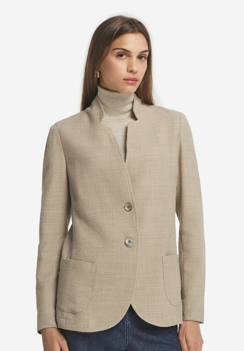 Beige texturerad kavaj med sjalkrage, två framfickor och två knappstängning. Slätt tyg med en strukturerad passform.