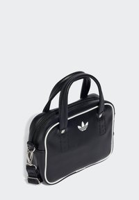 Black leather handbag with white piping, zip closure, top handles, and an embossed logo on the front. Compact rectangular shape.