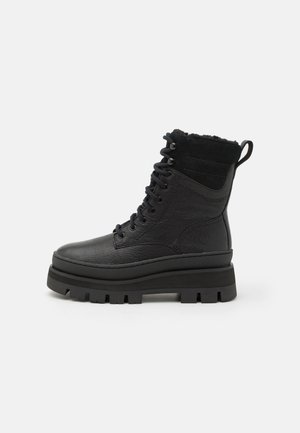 Black ankle boots featuring a textured leather upper, lace-up front, padded collar, and thick, rugged rubber sole for traction.