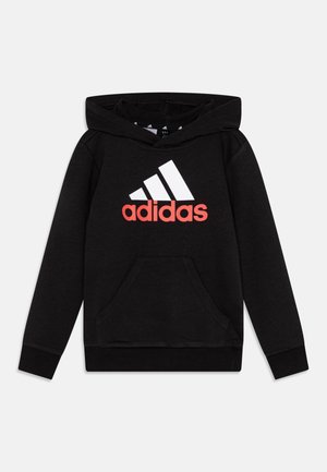 Felpa nera con cappuccio e tasca frontale, con logo Adidas bianco e dettagli rossi. Realizzata in un morbido tessuto testurizzato, con cappuccio regolabile tramite un cordoncino.