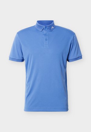 Hellblaues Polohemd mit kurzen Ärmeln, drei Knöpfen und einem kleinen weißen Markenlogo am Kragen vor einem einfarbigen Hintergrund.