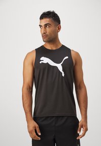 Zwarte sportieve tanktop met een witte springende poema logo op de voorkant. Gemaakt van een gladde, lichtgewicht stof. Model draagt zwarte shorts.