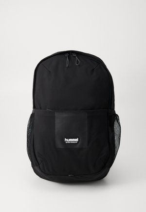 Sort rygsæk lavet af holdbart stof, med lynlåslukning, frontmesh-lomme og et logo-patch på frontpanelet.