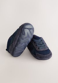 Scarpe per bambini in blu navy con materiali in rete e scamosciato, suola in gomma strutturata, chiusura con lacci e ritagli decorativi sui lati.